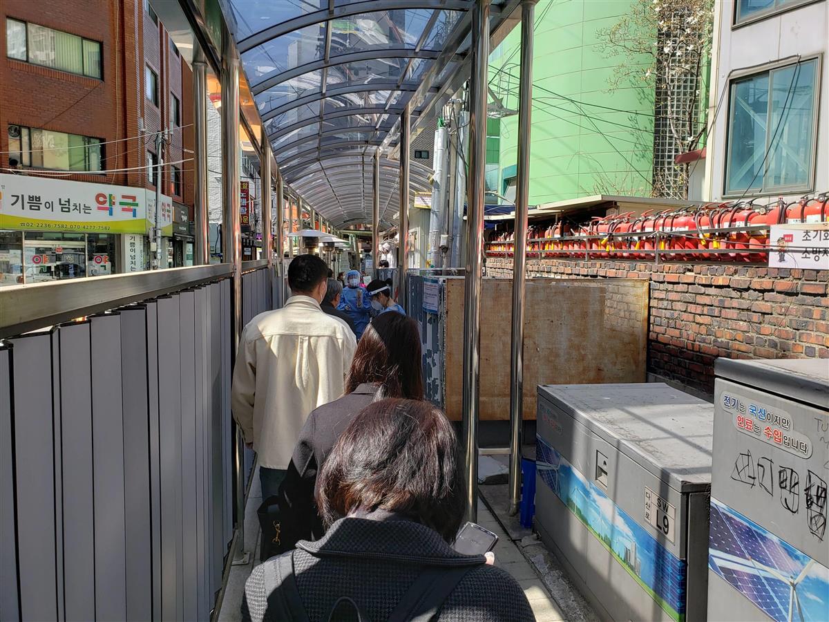 区の保健所に設置されたPCR検査場で順番を待つ人々。海外からの入国者と地元の人を隔てる措置はない=3月31日、ソウル市中区