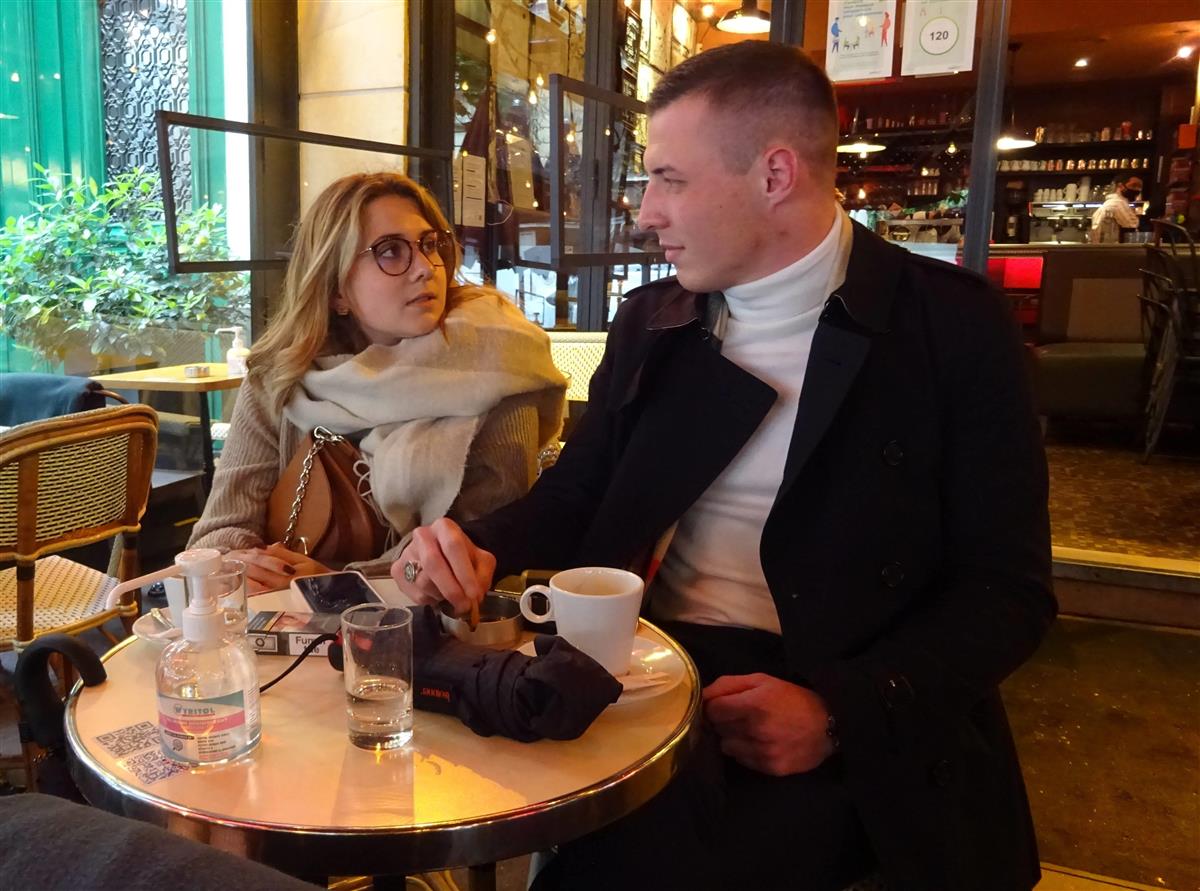 １９日から営業を再開したパリのカフェで、恋人と談笑するビルコ・ケタンさん（右）＝三井美奈撮影