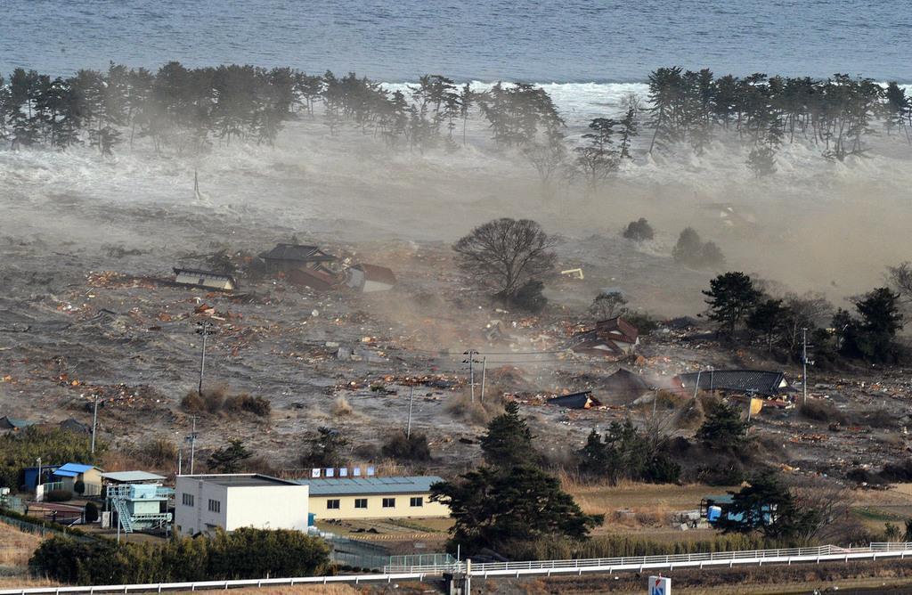 海岸沿いの住宅に押し寄せる東日本大震災の巨大津波=2011年3月11日、宮城県名取市