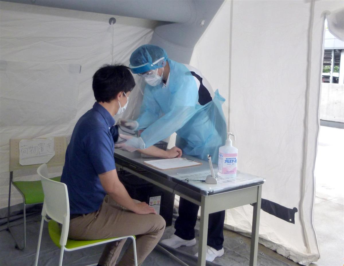 敷地内に設置されたテントで発熱患者らの容体チェックを行う医療スタッフ =川崎市立井田病院(同院提供)