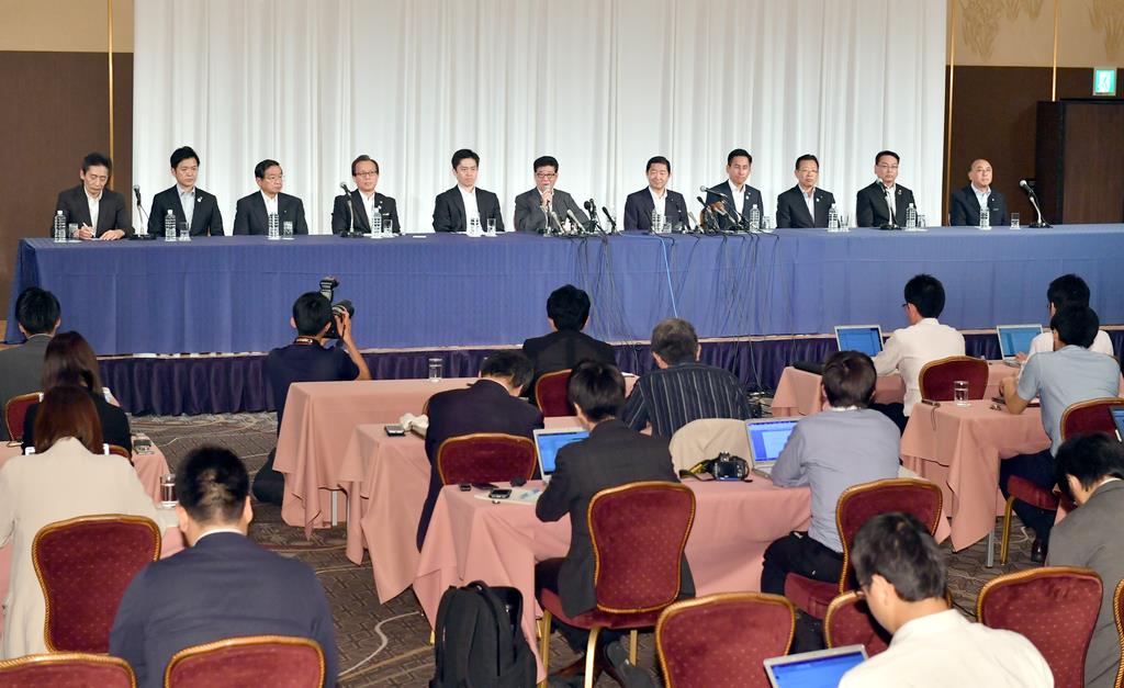 大阪維新の会代表の松井一郎大阪市長(左から6人目)、公明党大阪府本部の佐藤茂樹代表(同7人目)らの会見には多数の報道陣が集まった=25日午後、大阪市北区(沢野貴信撮影)
