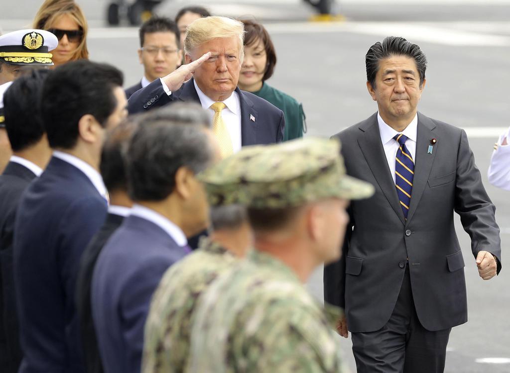 安倍首相(右)の出迎えを受け、海上自衛隊の護衛艦「かが」に乗艦したトランプ米大統領=28日午前、神奈川県横須賀市の海上自衛隊横須賀基地(代表撮影)