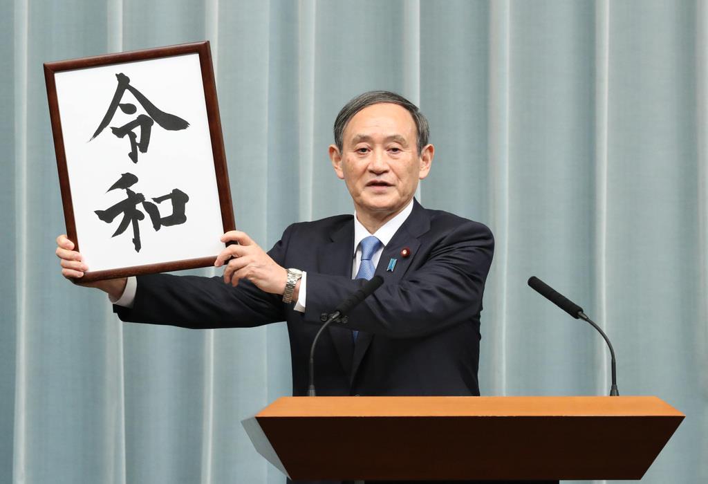 「令和(れいわ)」と書かれた墨書を掲げる菅義偉官房長官=4月1日、首相官邸(春名中撮影)