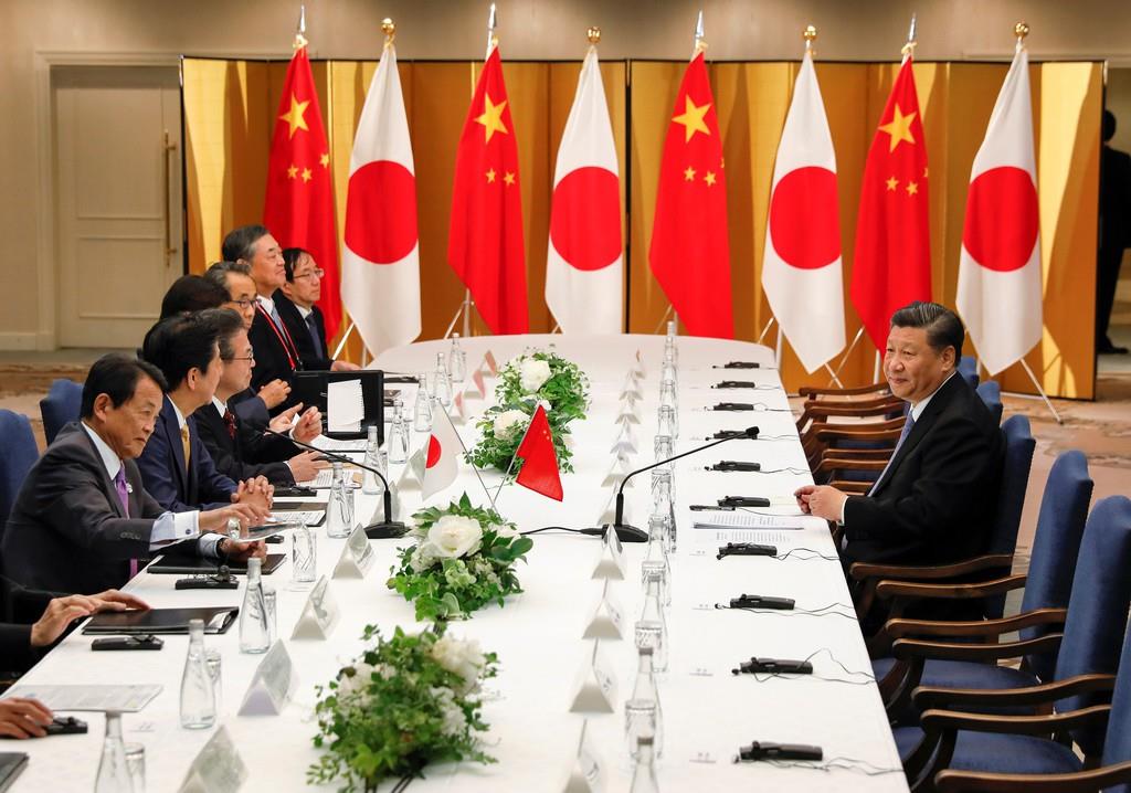日中首脳会談で、同席者を待つ中国の習近平国家主席(右)=6月27日、大阪市内のホテル(代表撮影・ロイター)