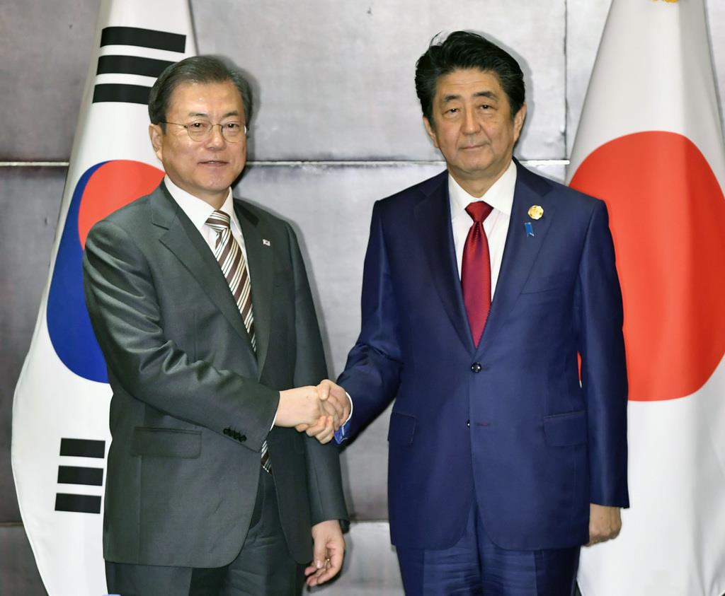 会談を前に握手を交わした韓国の文在寅大統領（左）と安倍首相＝中国・成都（共同）