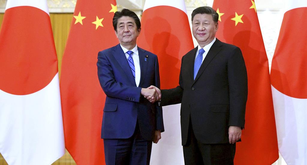 中国の習近平国家主席(右)と握手する安倍晋三首相=令和元年12月23日、北京の人民大会堂(AP)