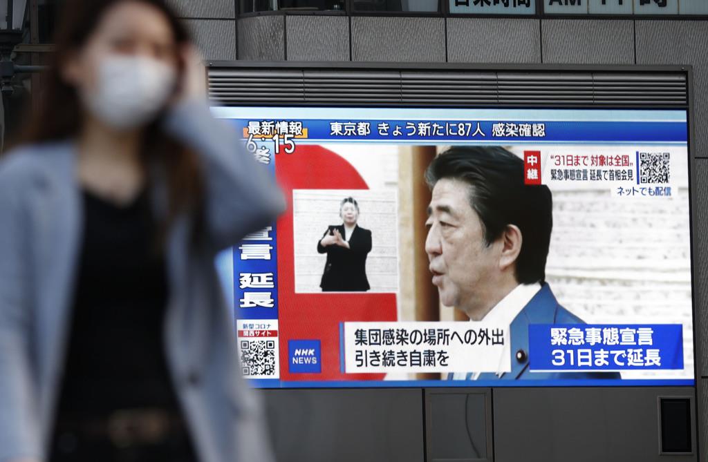 安倍首相が緊急事態宣言の延長を表明したことを伝える大阪・道頓堀のモニター=4日午後6時15分