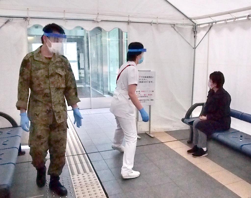 病院の入り口前に設置したテントで検温や問診を行う医療スタッフ=4月30日、東京都世田谷区の自衛隊中央病院(田中一世撮影)