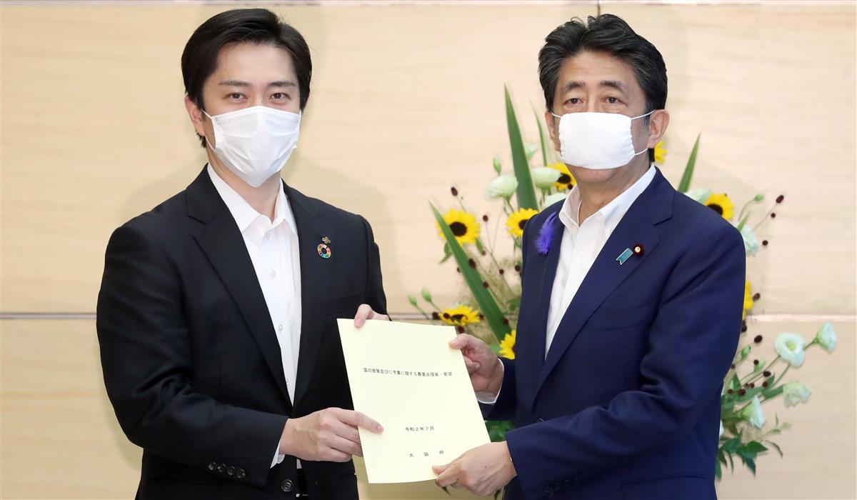 安倍晋三首相へ新型コロナウイルス感染対策などの要望書を手渡す吉村洋文大阪府知事(左)=14日午後、首相官邸(春名中撮影)