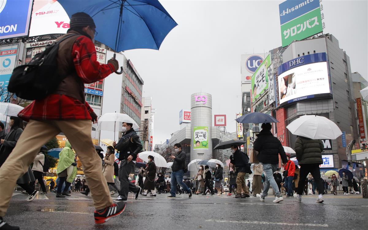 緊急事態宣言発令中の東京・渋谷で、雨の中スクランブル交差点を行き交う人々=23日午後、東京都渋谷区(萩原悠久人撮影)