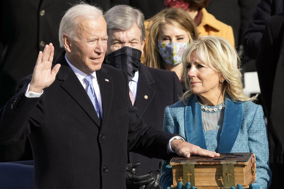 20日、就任式で宣誓するバイデン米大統領(左)=ワシントン(AP)