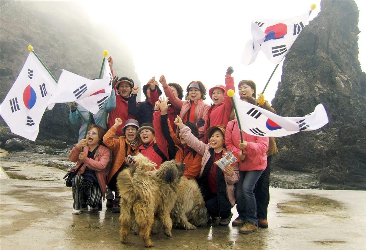 竹島(韓国名・独島)に上陸し、記念撮影する韓国の観光客ら(聯合=共同)