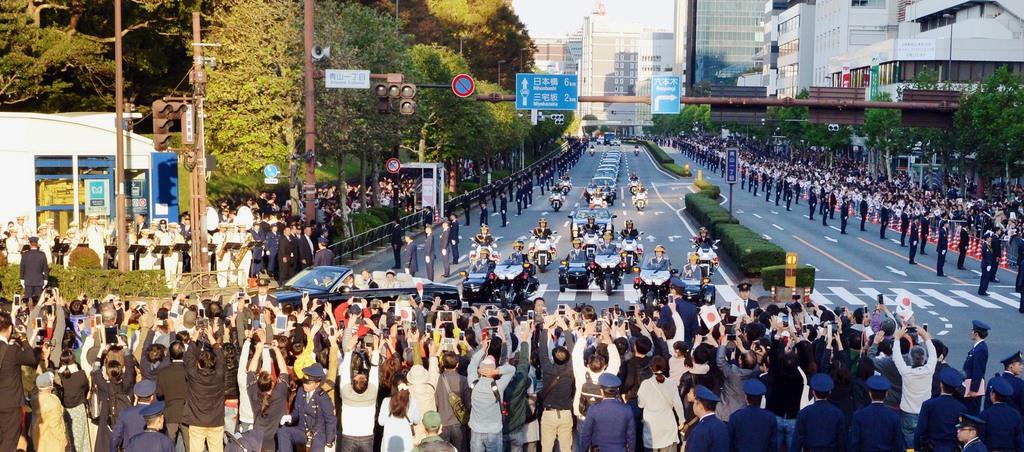 オープンカーでパレードされる天皇、皇后両陛下を撮影しようとする沿道の人々＝１０日午後、東京都港区の青山通り（植村光貴撮影）