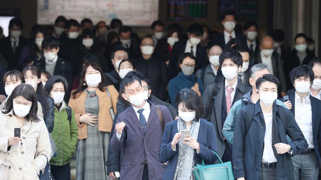 マスク姿で通勤する人々＝６日午前、東京都千代田区（松井英幸撮影）