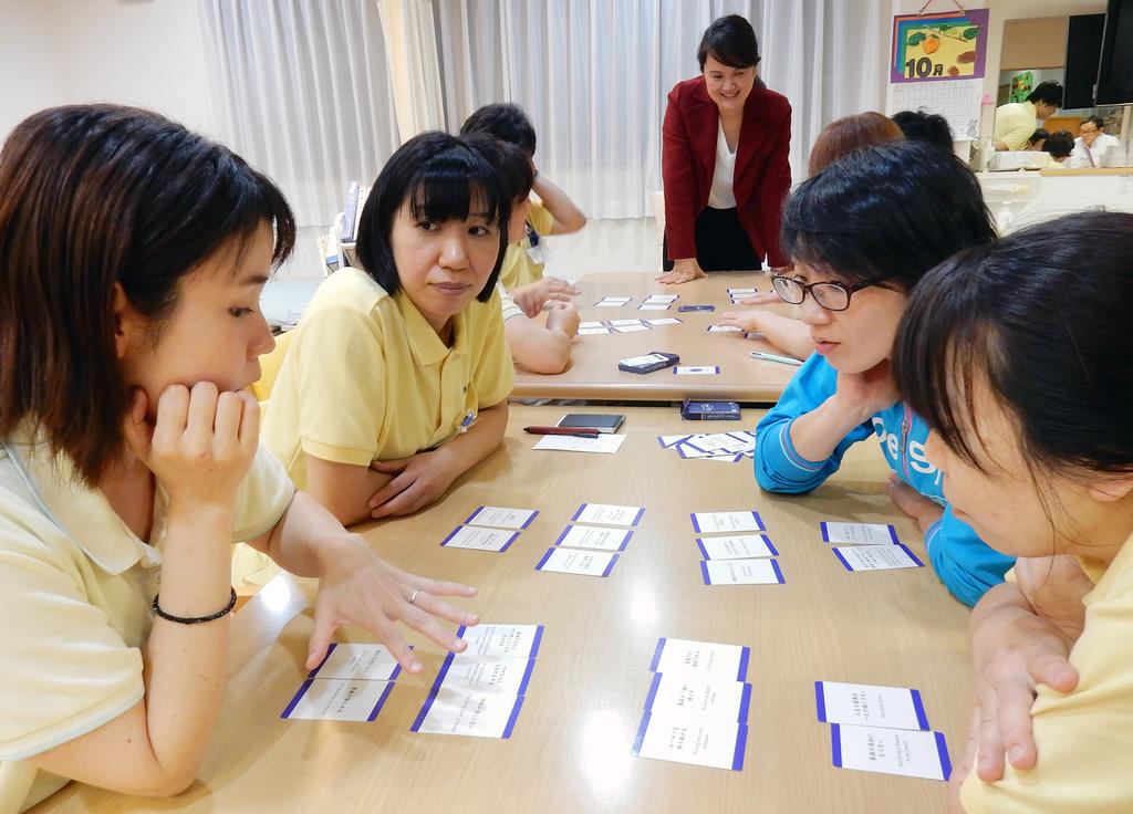 「もしバナゲーム」を使って死生観を語り合う介護やリハビリの職員たち＝大阪府茨木市