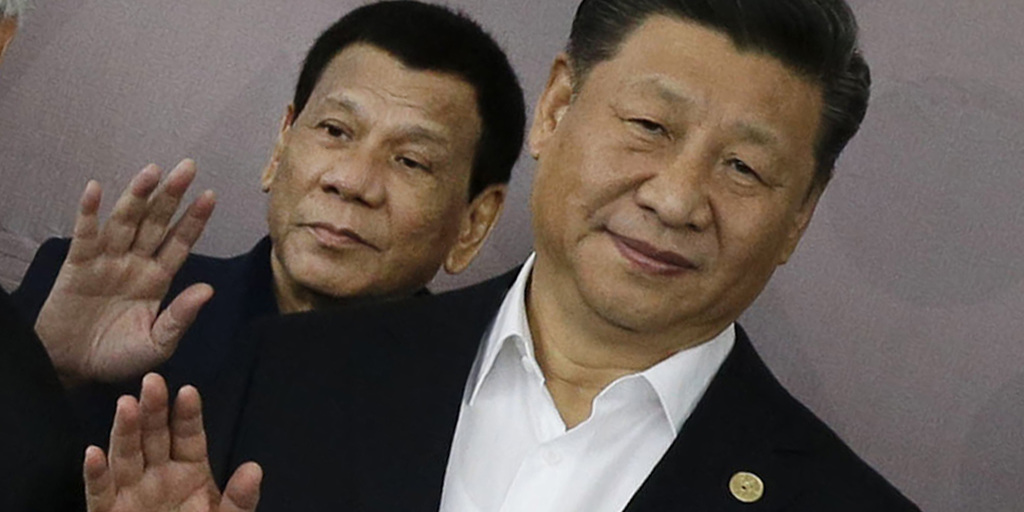 ＡＰＥＣ会場で撮影のために手を振るフィリピンのドゥテルテ大統領（左）と中国の習近平国家主席＝１８日、パプアニューギニア・ポートモレスビー（ＡＰ）