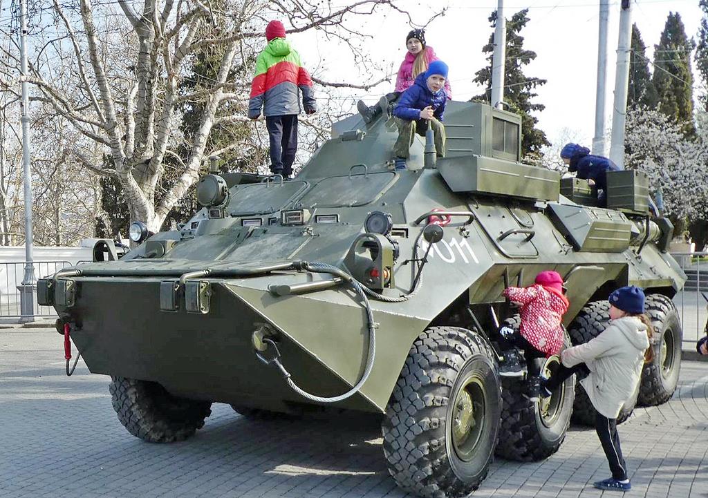 ロシアによる併合から５年を迎え、クリミア半島のセバストポリに展示された軍用車両で遊ぶ子供たち。ロシアでは愛国教育が強化されている＝１６日