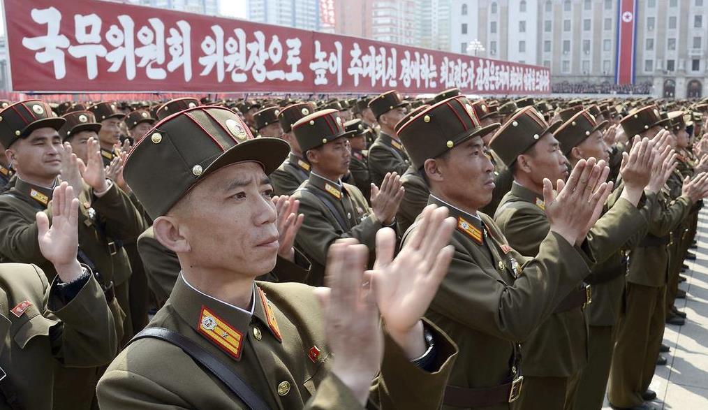 金正恩氏の国務委員長再任を祝う大会で、拍手する朝鮮人民軍の兵士=13日、平壌の金日成広場(共同)