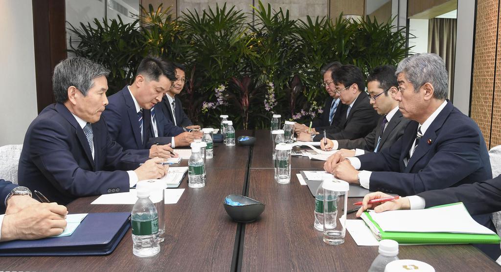 非公式に会談する岩屋防衛相(右端)と韓国の鄭景斗国防相(左端)=1日、シンガポール(防衛省提供)