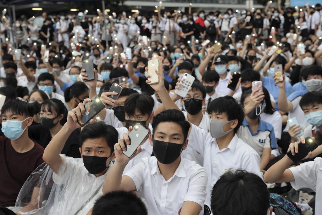 抗議集会に参加し、ライトを点けたスマートフォンを掲げる学生ら＝２日、香港（ＡＰ）