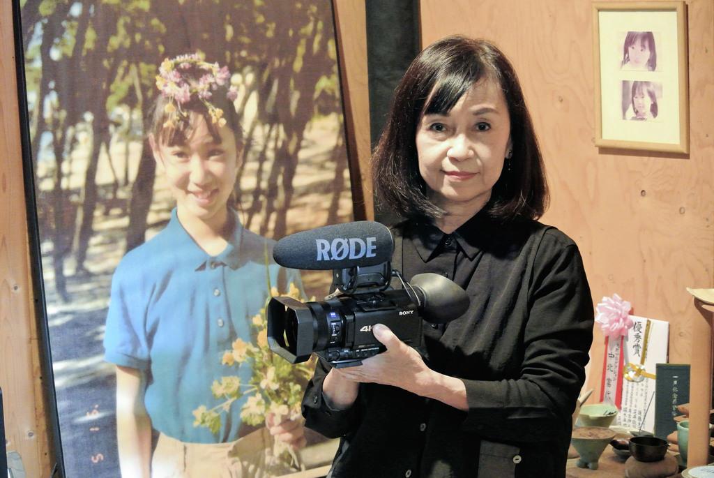 撮影に使用したカメラを手にする中北富代さん。奥は長女百合さんの写真=兵庫県西宮市