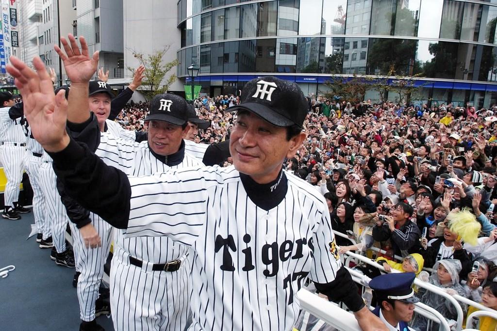 優勝パレードで沿道を埋めるファンの声援にこたえる星野仙一さん
