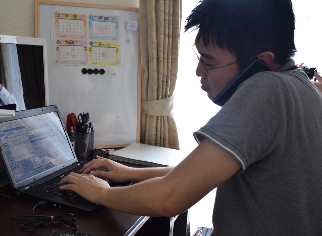 自宅にいながらテレワークで会議に参加する経済産業省の職員