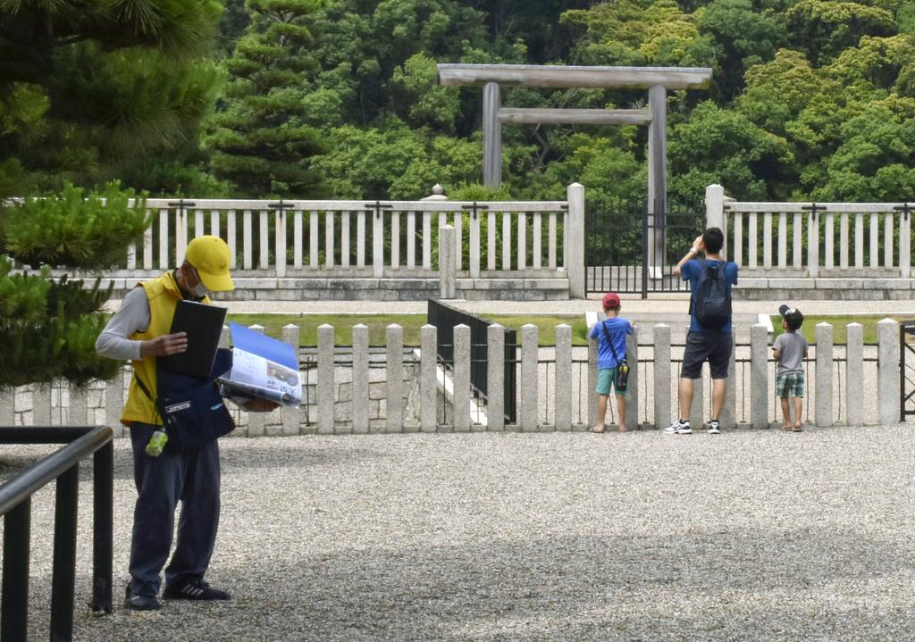 観光客がまばらな仁徳天皇陵古墳(大山古墳)。左端は古墳を紹介するボランティア=6月、堺市