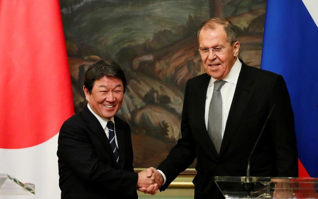 12月19日、モスクワでの会談後、共同記者発表で握手する茂木敏充外相(左)とロシアのラブロフ外相(ロイター)