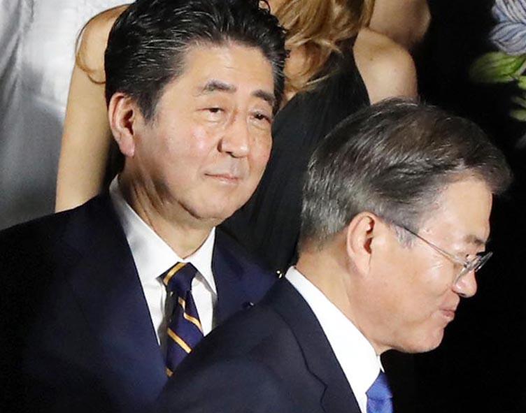 G20大阪サミットで、集合写真の撮影を前に、安倍晋三首相(中央)の前を歩く韓国の文在寅大統領(右)=6月28日、大阪市中央区(代表撮影)