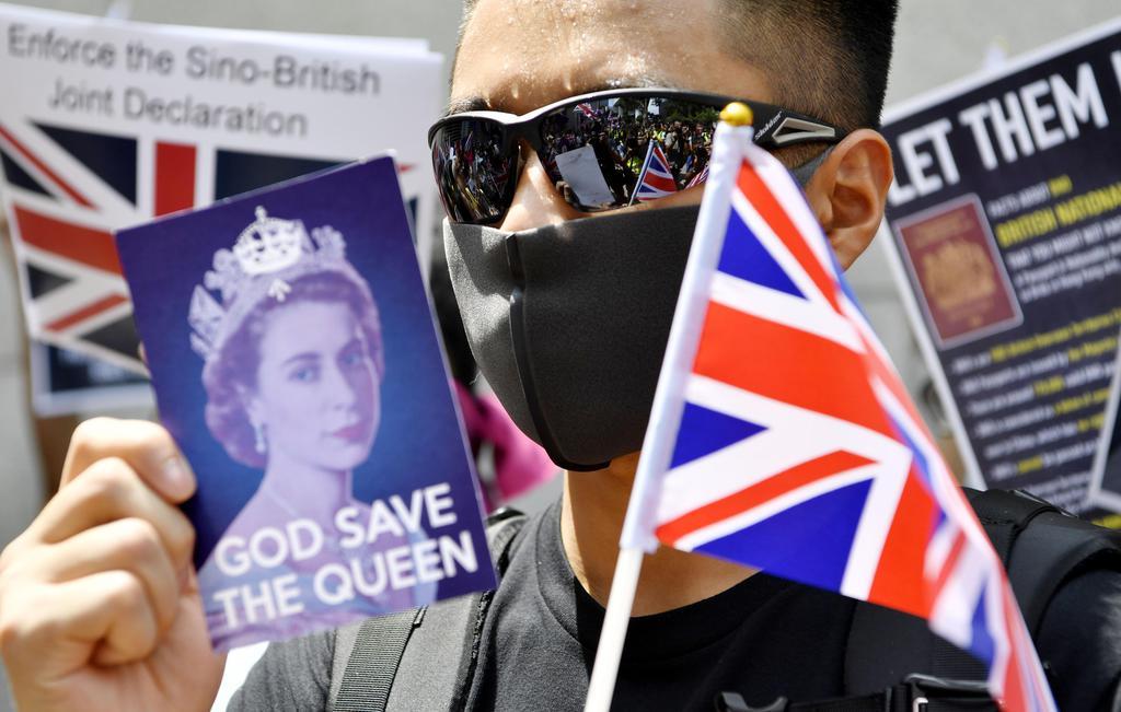 香港の英国総領事館前で、英国旗を手に支援を求める男性＝１５日（共同）