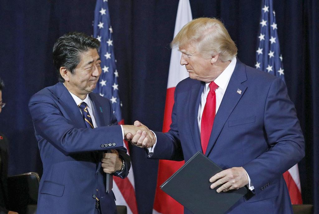 日米貿易協定締結で最終合意し、合意文書への署名を終えて握手する安倍首相(左)とトランプ大統領=9月25日、米ニューヨーク(共同)