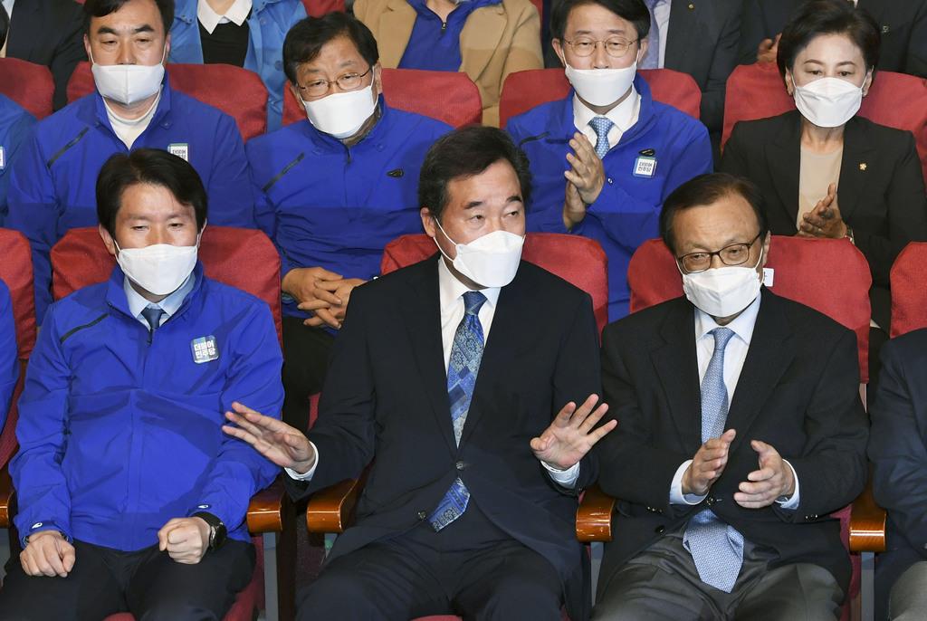 15日、韓国総選挙で出口調査の報道を見守る韓国の与党「共に民主党」の李洛淵前首相(前列中央)ら=ソウル(共同)