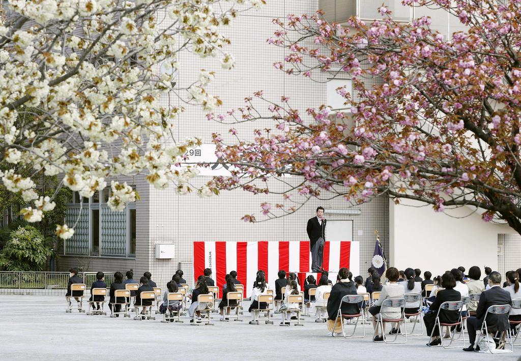 ４月６日、桜の花が咲く中で開催された、東京都足立区立小学校の入学式。新型コロナウイルス感染防止のため校庭で行われた