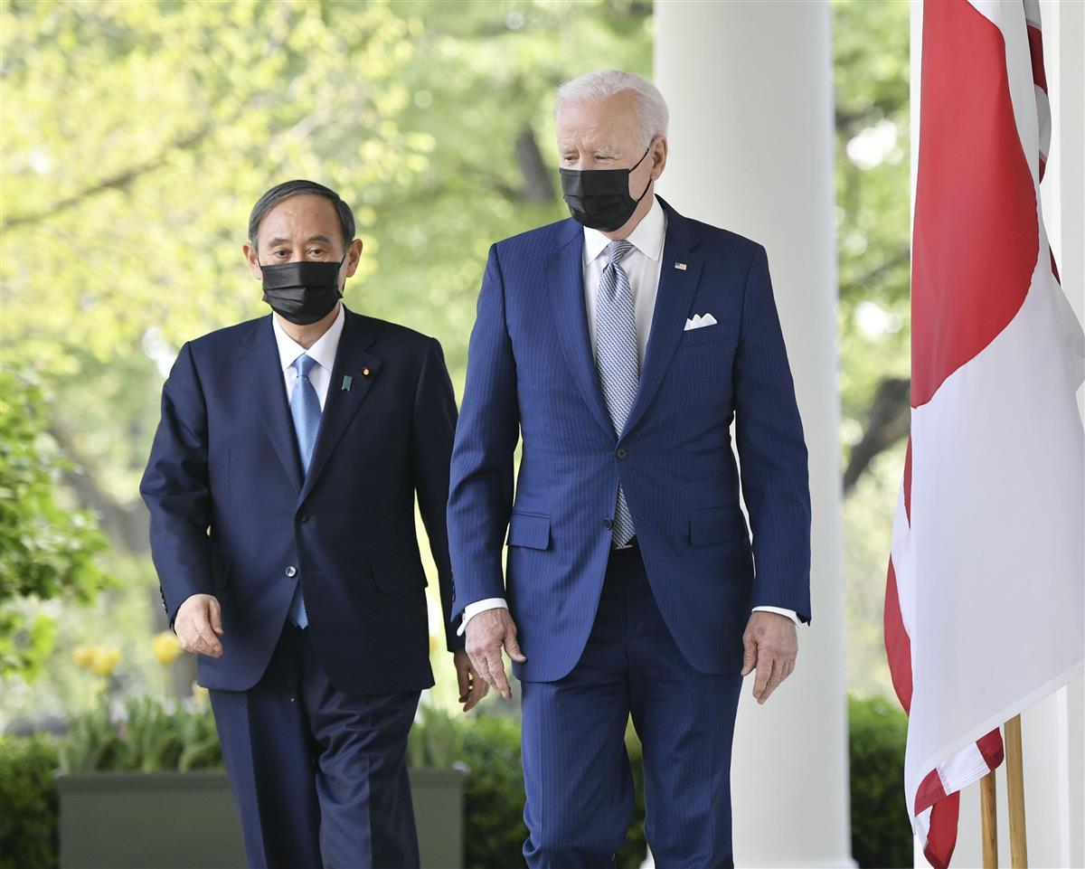 会談後、共同記者会見に向かう菅首相(左)とバイデン米大統領=16日、ワシントンのホワイトハウス(共同)
